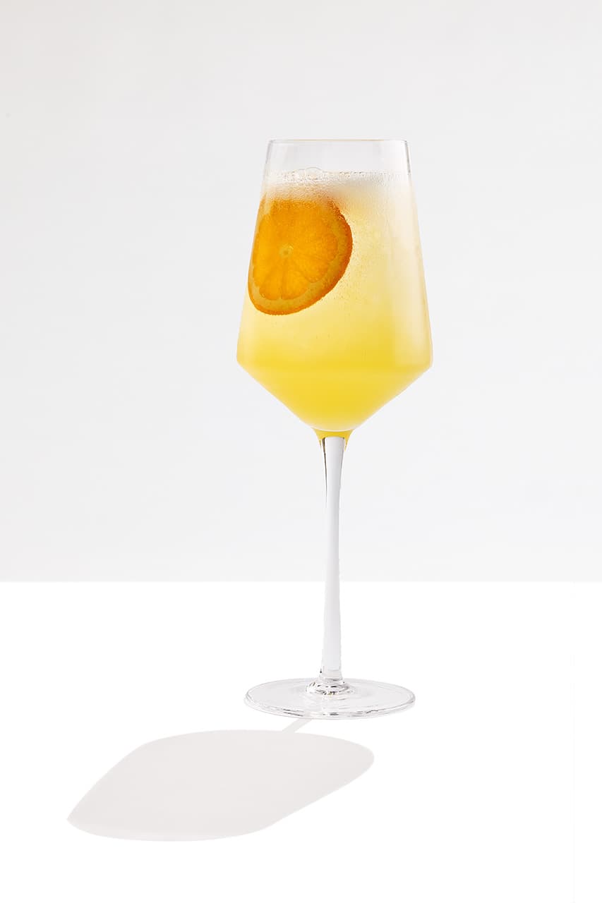 Two Gin Spritz cocktails made with Tanqueray Sevilla Orange and garnished with orange slices.