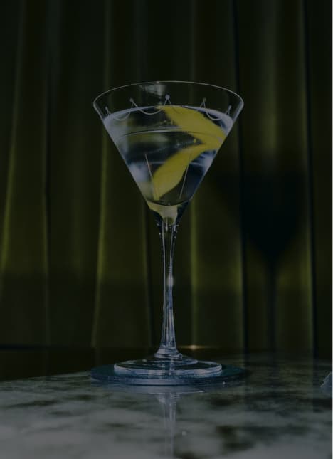 A Connaught Martini Cocktail sitting on a bar